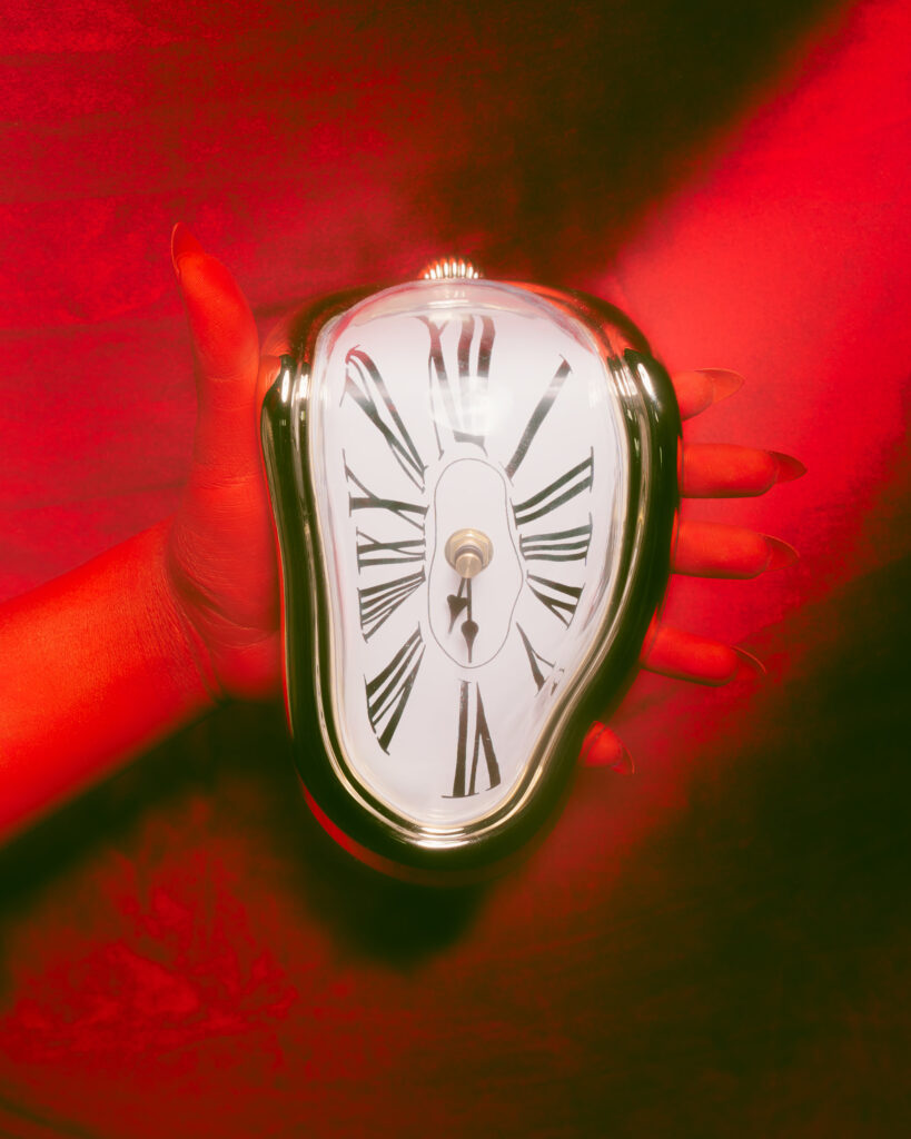 Uhr schmilzt auf rotem Hintergrund 