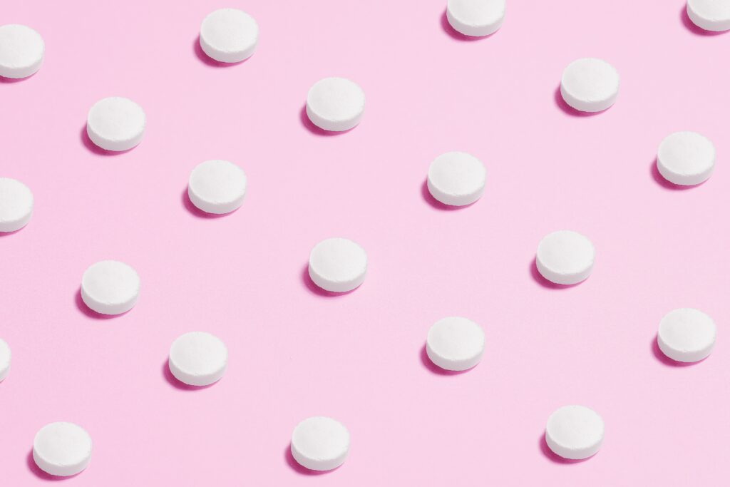 weiße Pillen auf rosarotem Hintergrund