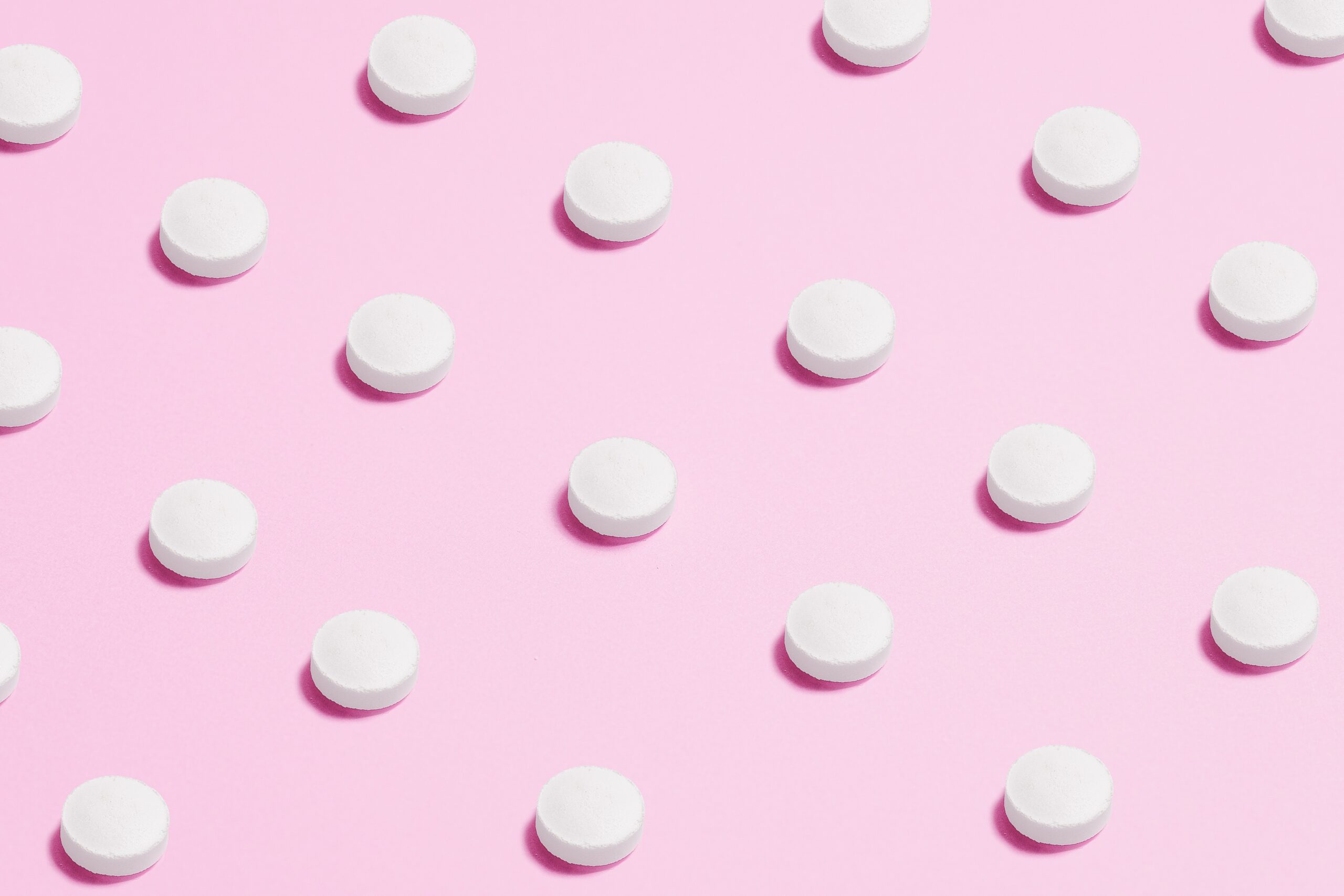 weiße Pillen auf rosarotem Hintergrund