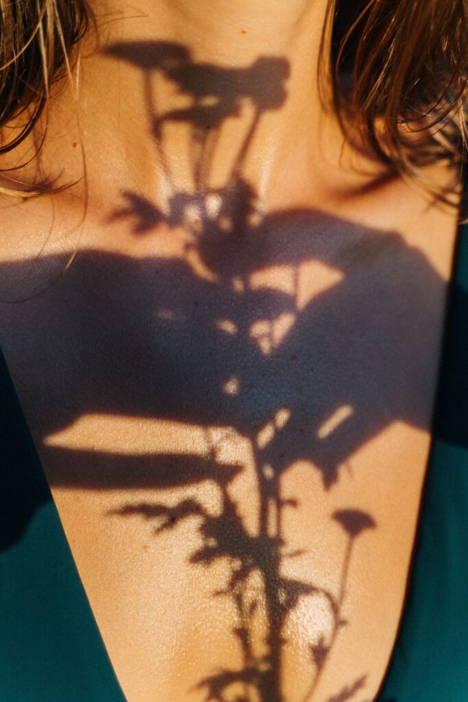 Schatten einer Pflanze auf der Brust einer Frau