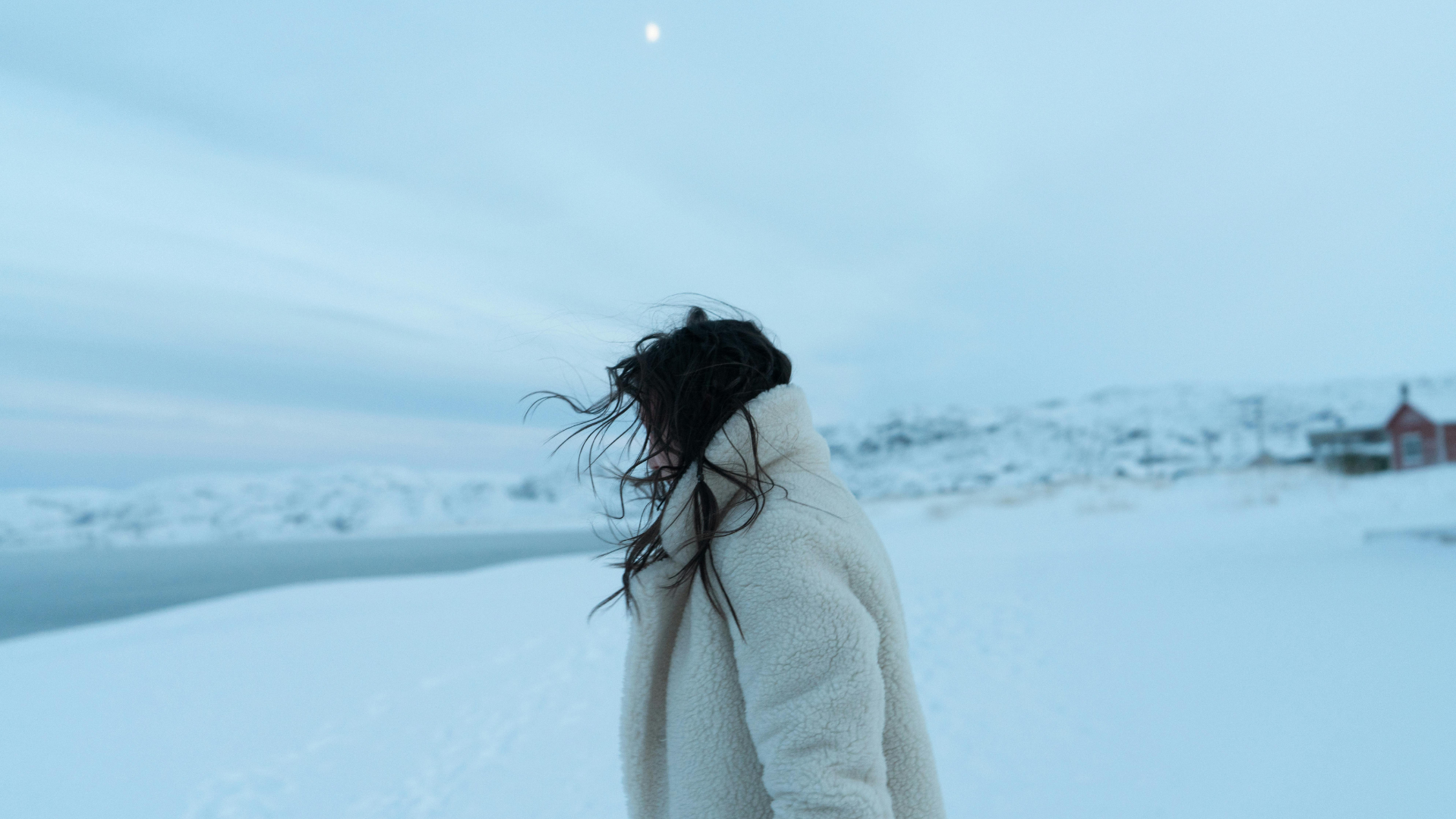 Frau in flauschiger Jacke vor Winterlandschaft