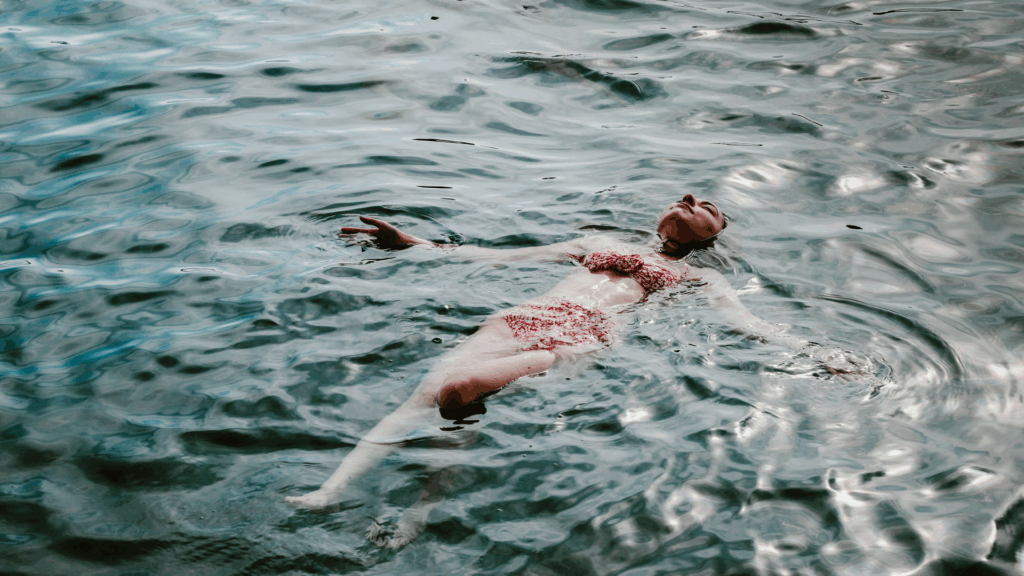 Eine Frau schwimmt auf dem Rücken im Wasser