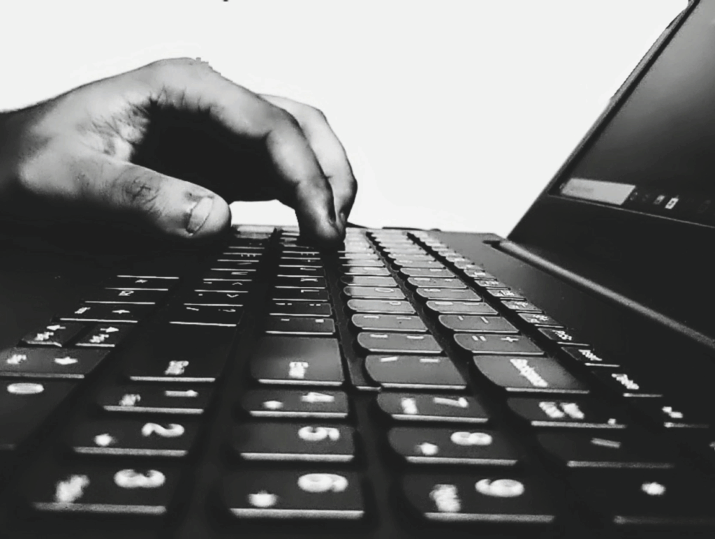 Eine Hand tippt auf der Tastatur eines Laptops