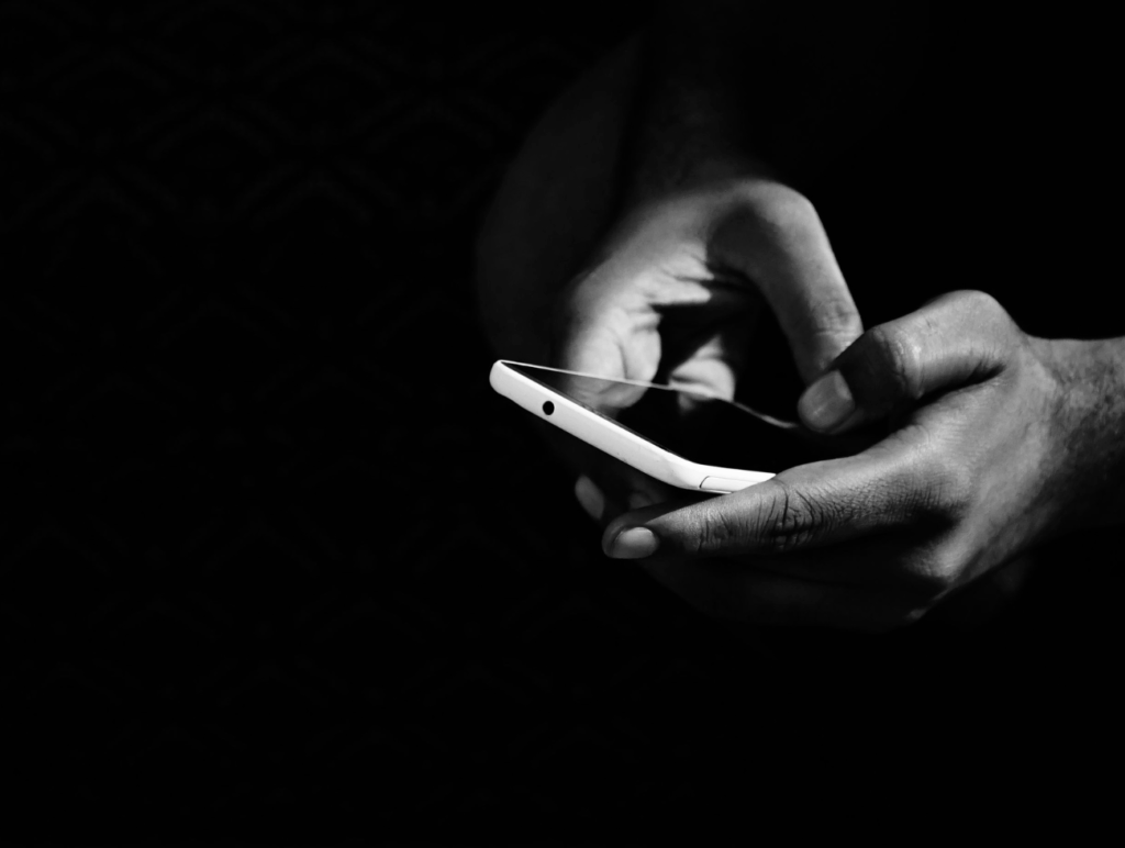Hände mit einem Handy in der Hand