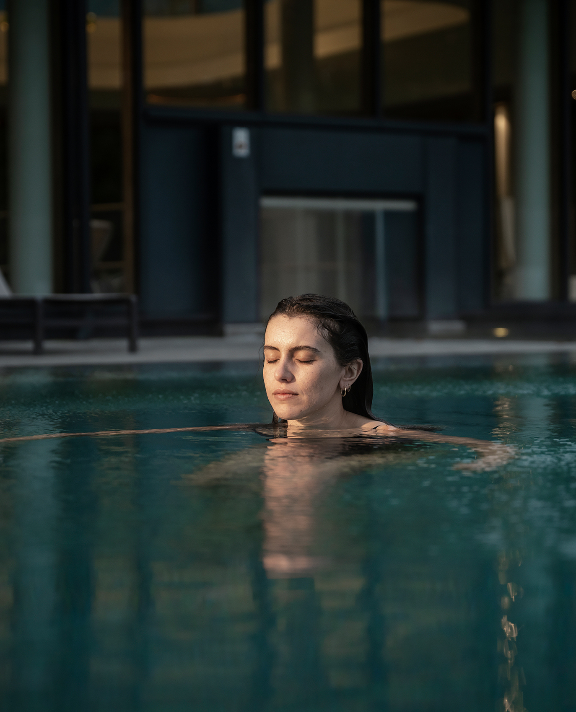 Eine Frau mit geschlossenen Augen im Pool