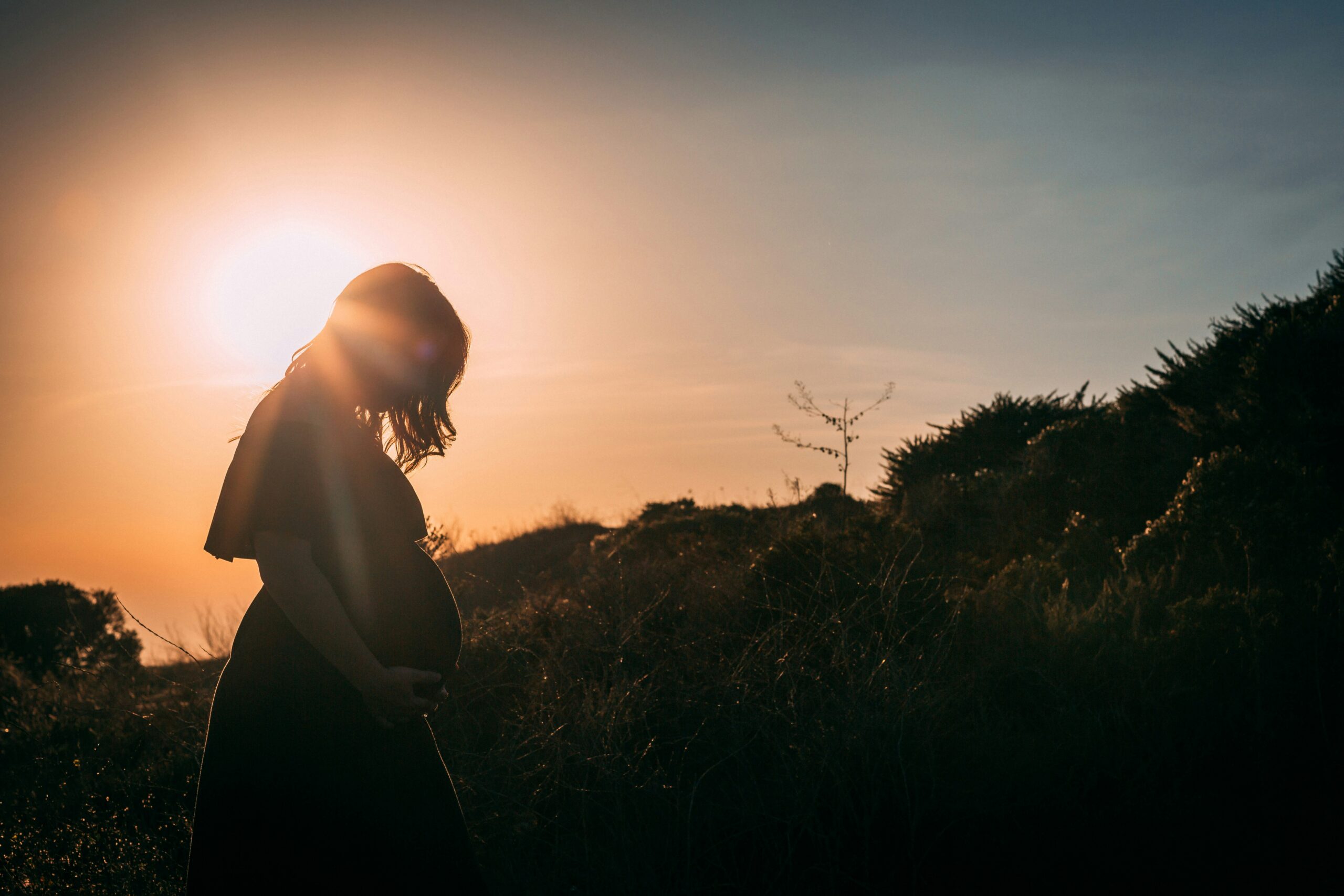 Folsäure und der weibliche Körper, Symbolfoto, Sonnenuntergang, warmes Licht, Frau schwanger